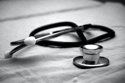 Greyscale photograph of a stethoscope on a desk